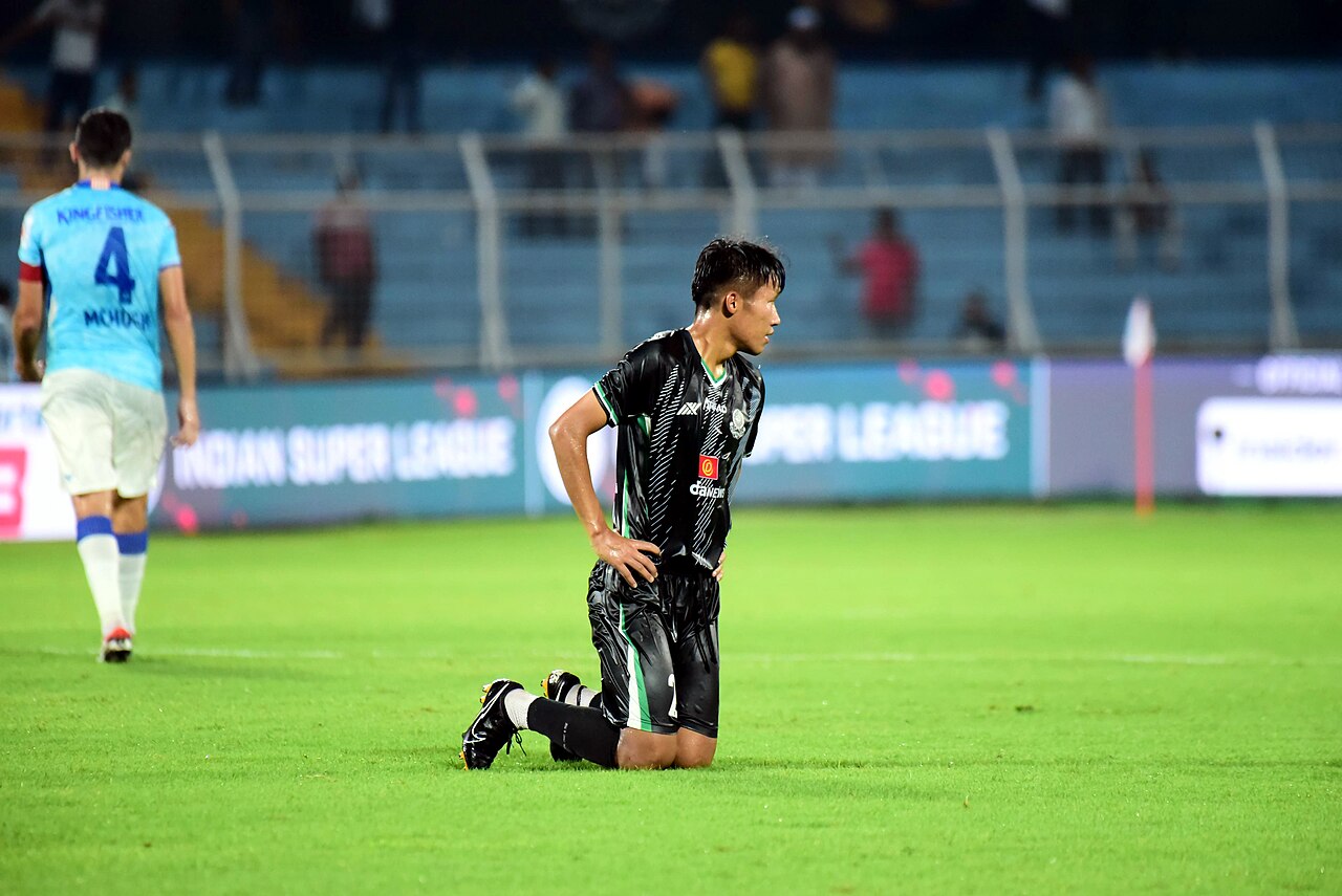 FairPlay ISL Football Betting: Indian Super League match markets on a phone beside the trophy and a match ball